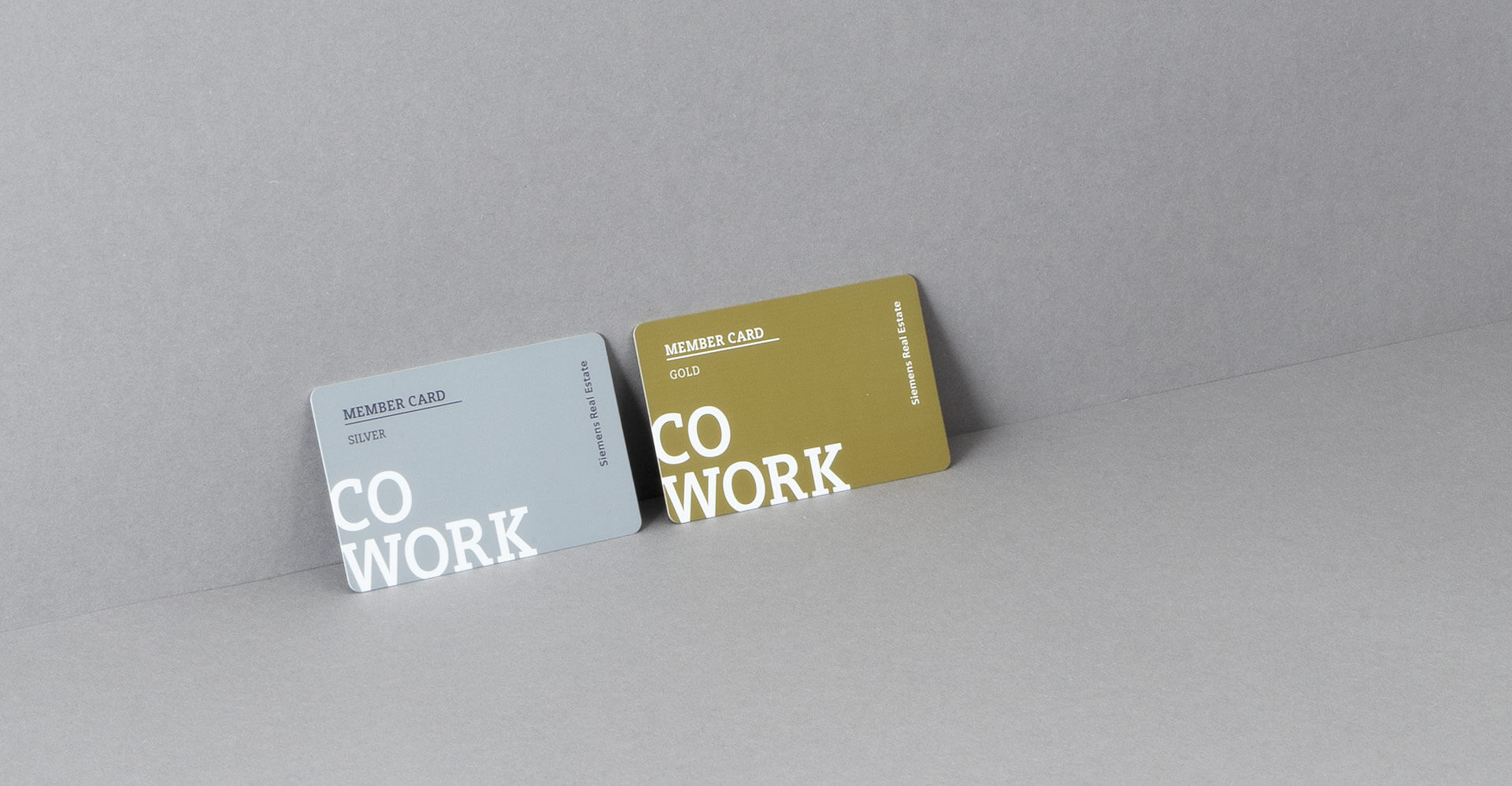 Silberne und goldene Member Card von Siemens Coworking Space auf grauem Untergrund