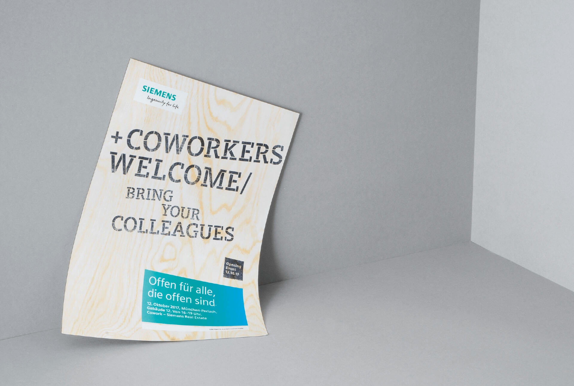Werbeplakat für Siemens Coworking Space mit Text Coworkers Welcome/ Bring your colleagues mit Holztextur im Hintergrund liegt in einer grauen Ecke