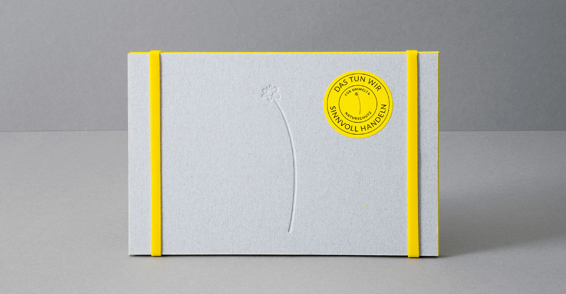 Mailing mit Werkpappe für die Natuschutzinitiative "sinnvoll handeln" mit gelben Gummibändern aus Kautschuk und Naturschutz-Siegel