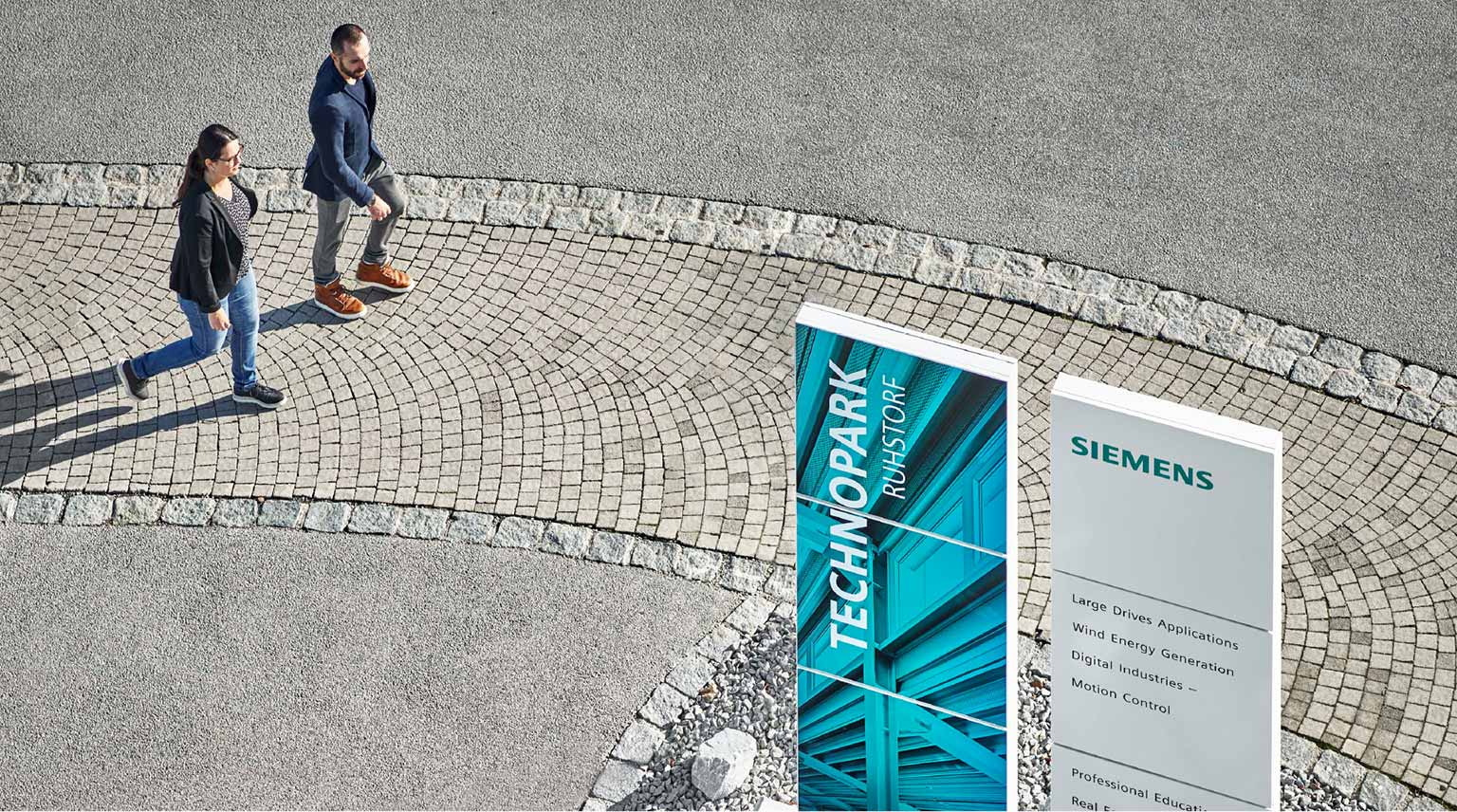 Stelen im Siemens Technopark Ruhstorf an denen Menschen vorbeilaufen aus erhöhter Perspektive