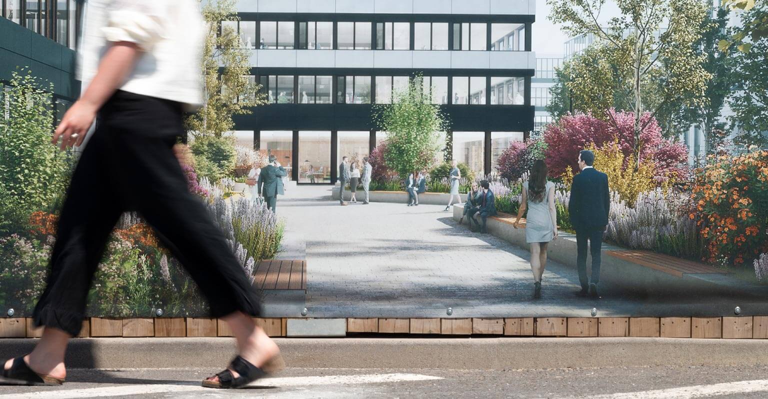 Frau läuft vorbei an Bauzaun von The Move auf dem ein Gebäude und Pflanzen abgebildet sind