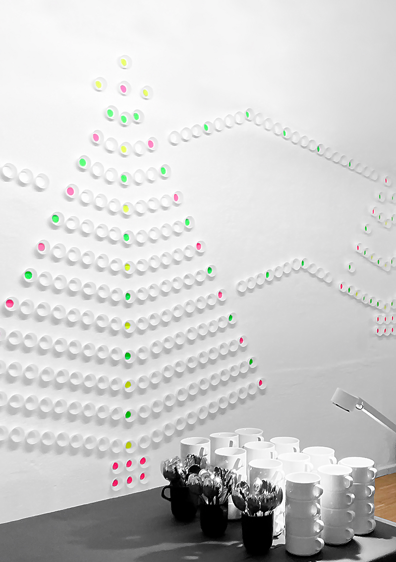 Weihnachtliche Rauminszenierung durch bunte, an der Wand befestigten Cupcake Formen, welche einen Baum darstellen