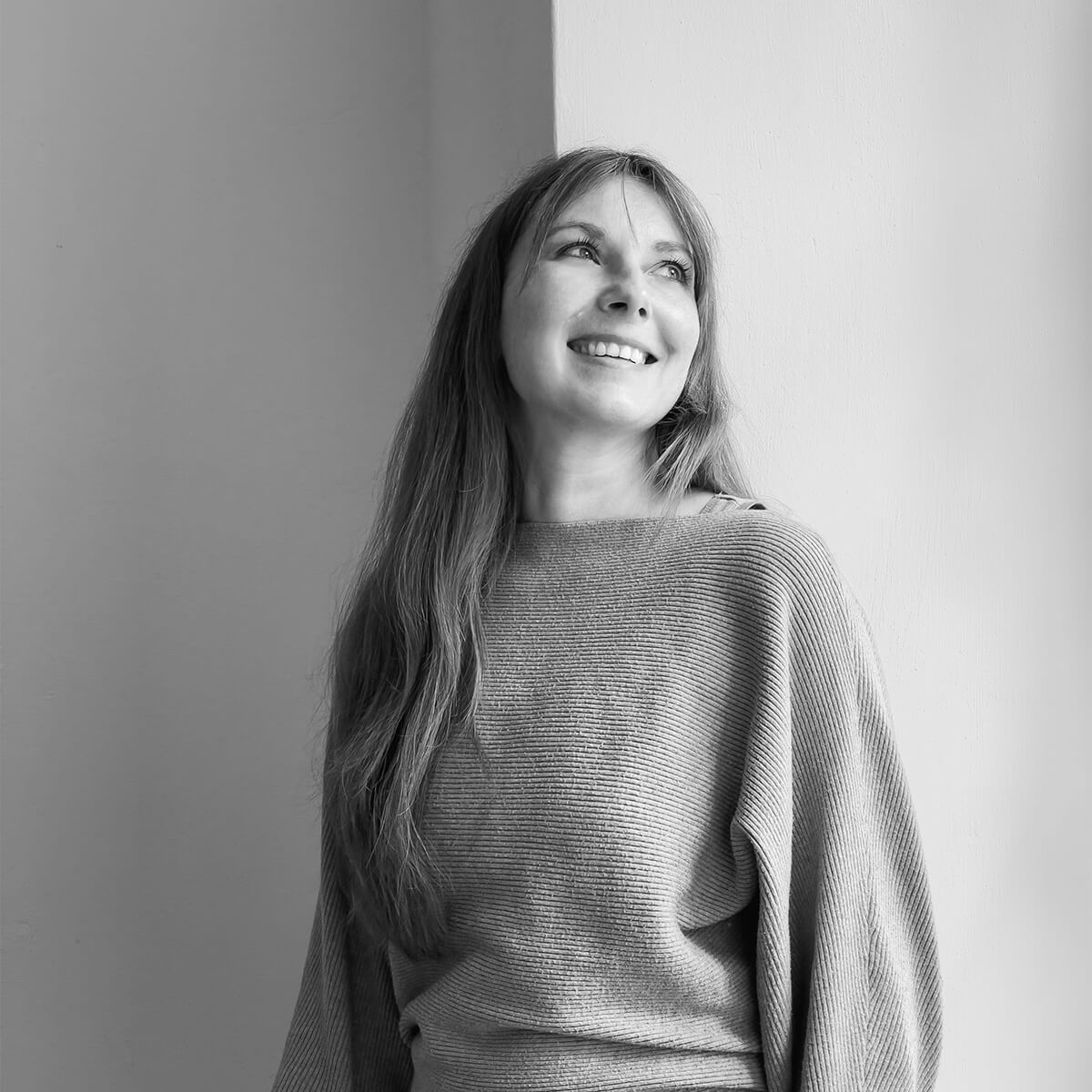 haefelinger design Mitarbeiterin Isabel Gutberlet lacht und steht an einer Ecke als schwarzweiß Foto