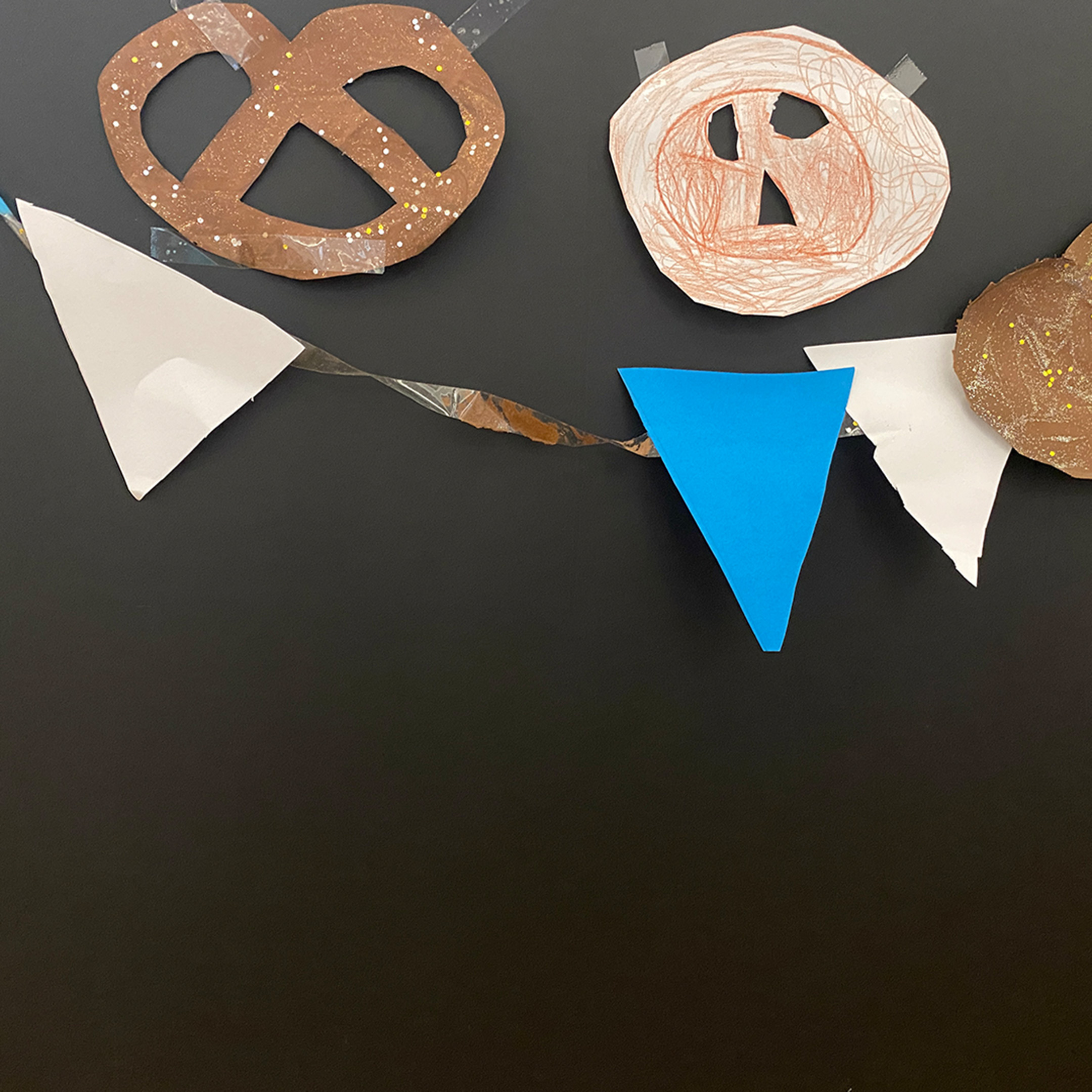 Eine fröhliche Collage mit Breze und blauen und weißen Wimpeln